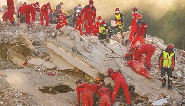 Rescue personnel search for survivors in the debris of a collapsed building in the Bayrakli district of Izmir yesterday, after a powerful earthquake struck Turkey's western coast and parts of Greece. 