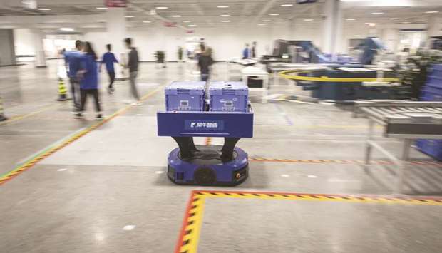 A delivery robot moves through the Xunxi factory in Alibabau2019s hometown of Hangzhou. Alibabau2019s path to smart manufacturing starts with garments, a market worth 2.2tn yuan ($328bn) in China last year based on Euromonitor Internationalu2019s estimates.