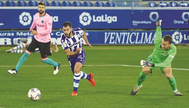 Alavesu2019 Spanish midfielder Luis Rioja (left) scores as Barcelonau2019s Brazilian goalkeeper Neto (right) helplessly looks on during the La Liga match at the Mendizorroza stadium in Vitoria, Spain, on Saturday night. (AFP)