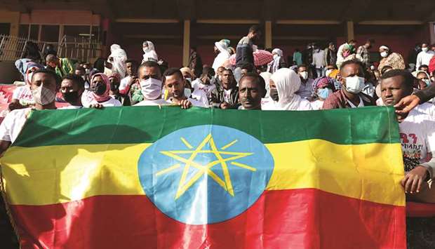 Volunteers hold an Ethiopian flag as they gather to donate blood for the injured members of Ethiopiau2019s National Defense Forces (ENDF) fighting against Tigrayu2019s special forces on the border between Amhara and Tigray, at the stadium in Addis Ababa.