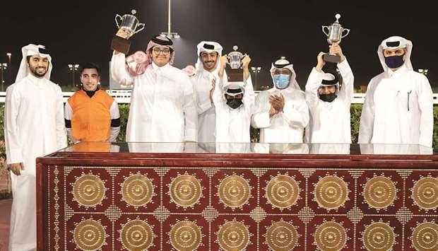 Qatar Racing and Equestrian Clubu2019s Abdulla Rashid al-Kubaisi (third from right) with the winners of the Doha Cup after Injaaz Studu2019s Lekhraib won the 1200m race at Al Rayyan Park yesterday. PICTURES: Juhaim