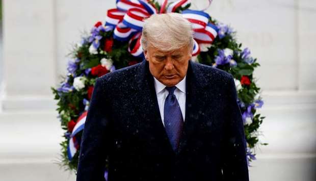 US President Donald Trump turns away in the rain after laying a wreath at the Tomb of the Unknown Solider as he attends a Veterans Day observance in Arlington National Cemetery in Arlington, Virginia