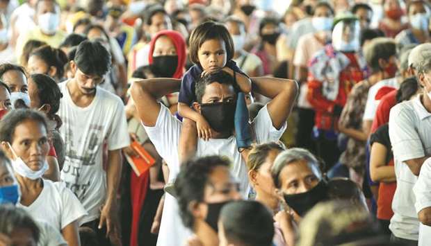 Residents affected by Typhoon Vamco gather during a distribution of face masks and relief goods in an evacuation centre, in Rodriguez, Rizal province, Philippines.