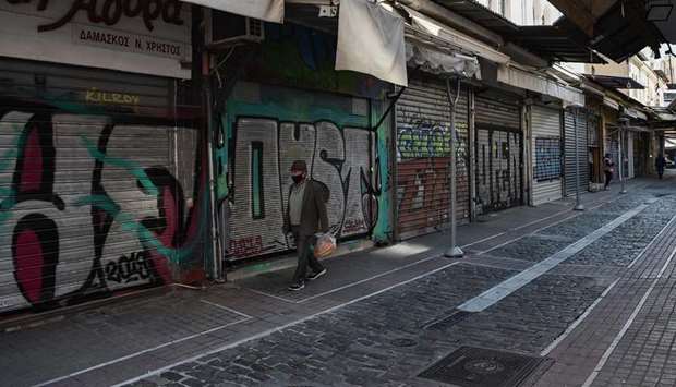 A man walks past shuttered shops in Thessaloniki yesterday during a second national lockdown in Greece aimed at curbing the spread of the coronavirus pandemic.