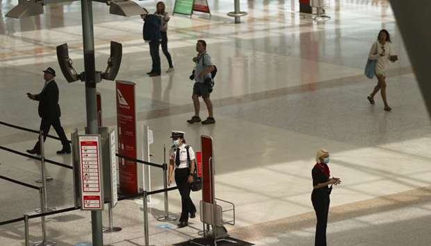 A masked crew member approaches security in a domestic terminal at Sydney Airport in Sydney