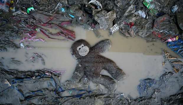 A stuffed toy is seen in mud following the flood brought by a typhoon