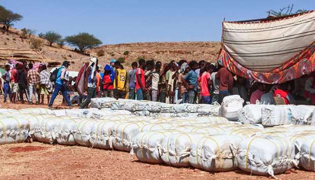 Ethiopian refugees fleeing fighting in Tigray province queue to receive supplies at the Um Rakuba camp in Sudan's eastern Gedaref province