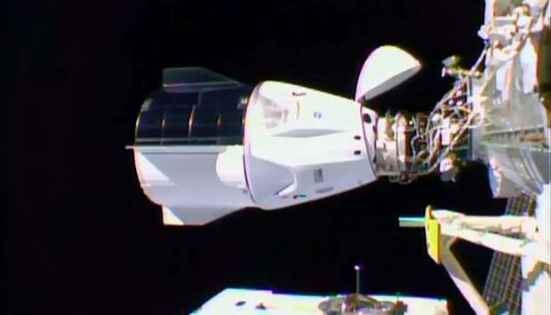 This NASA TV video grab shows Nasa's SpaceX Crew-1 mission aboard the SpaceX Crew Dragon (R) docked to the International Space Station (L)
