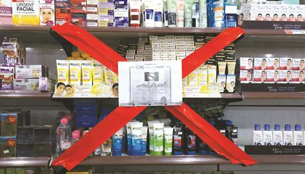 A boycott sign covers a store showcase displaying French products at a shop in Peshawar.