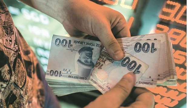 A money changer counts Turkish lira banknotes at a currency exchange office in Istanbul (file).
