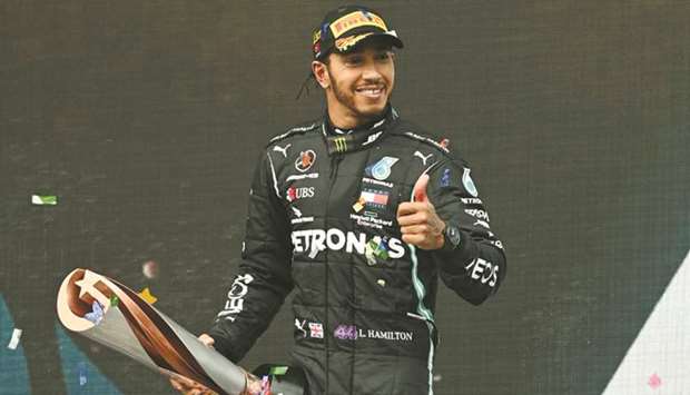 Mercedesu2019 Lewis Hamilton celebrates on the podium with a trophy after winning the Turkish Grand Prix and the world championship in Istanbul Park, Istanbul, on November 15, 2020. (Reuters)