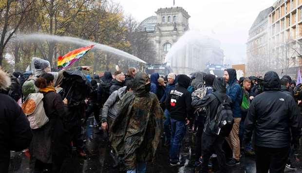 Police use a water cannon to disperse protesters demonstrating against measures imposed by the German government to limit the spread of the novel coronavirus