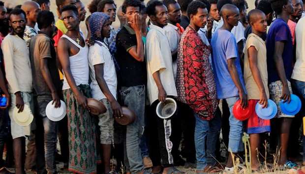 Ethiopian men who fled war in Tigray region, queue for wet food ration at the Um-Rakoba camp, on the Sudan-Ethiopia border in Al-Qadarif state, Sudan