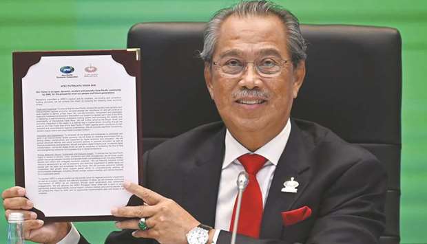 Malaysiau2019s Prime Minister Muhyiddin Yassin holds up a copy of the u201cApec Putrajaya Vision 2040u201d document during the online Asia-Pacific Economic Co-operation (Apec) leadersu2019 summit held in Kuala Lumpur yesterday.