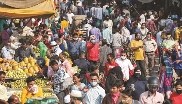 A health worker takes the temperature of shoppers at a crowded market amid the spread of the coronavirus disease, in Ahmedabad, yesterday.