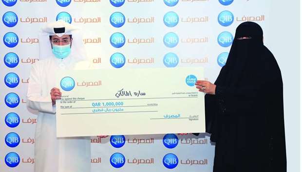 QIB customer Sara al-Malki receiving the grand prize at QIB's head office