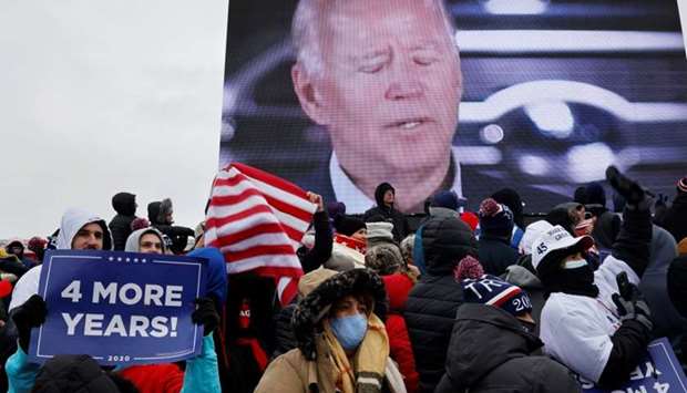 Democratic U.S. presidential nominee and former Vice President Joe Biden is seen on a screen as supporters attend a campaign rally by US President Donald Trump at Michigan Sports Stars Park in Washington, Michigan.