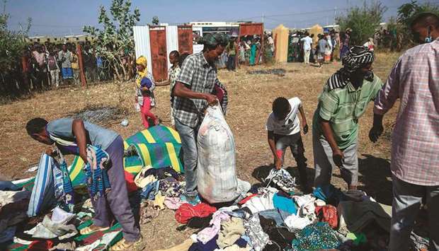 Ethiopian refugees who fled fighting in the Tigray Region receive clothing aid at the Village 8 border reception centre in Sudanu2019s eastern Gedaref State.