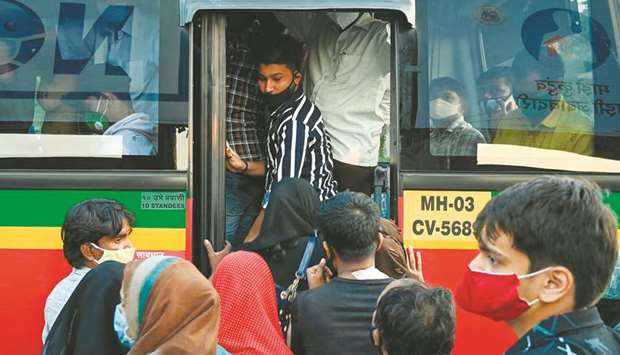 Passengers try to board a crowded bus in Mumbai yesterday.
