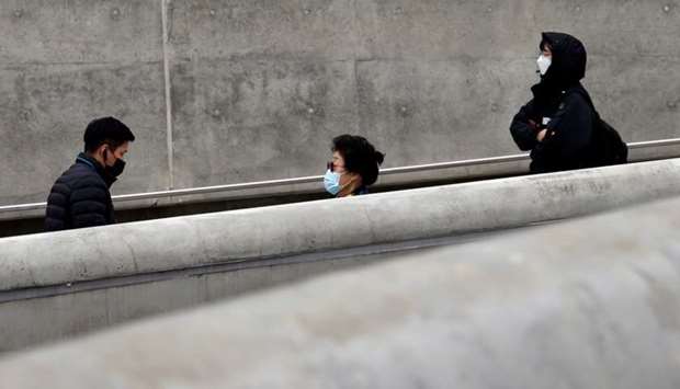 People wearing masks walk along a street amid the coronavirus disease pandemic in Seoul, South Korea