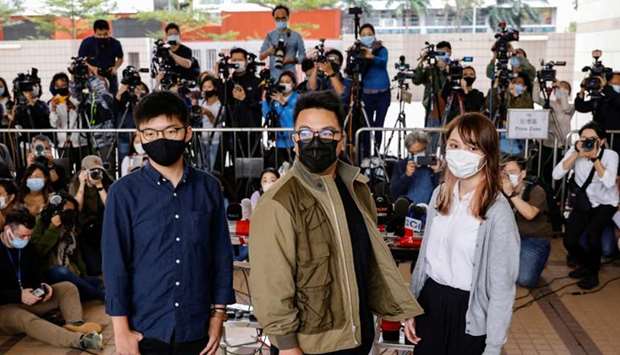 Pro-democracy activists Ivan Lam, Joshua Wong and Agnes Chow arrive at the West Kowloon Magistrates' Courts to face charges related to illegal assembly stemming from 2019, in Hong Kong, China