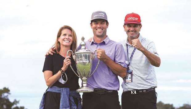 Robert Streb of the United States celebrates with the trophy alongside wife Maggie (left) and caddie Steve Catlin (right) after winning in a sudden-death playoff against Kevin Kisner (not pictured) during the final round of The RSM Classic at the Seaside Course at Sea Island Golf Club in St Simons Island, Georgia. (Getty Images/AFP)