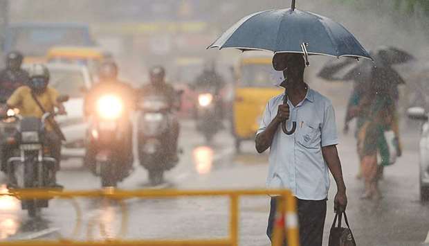 A man walks under an umbrella during heavy rains as cyclone Nivar approaches the eastern coast, in Chennai yesterday.