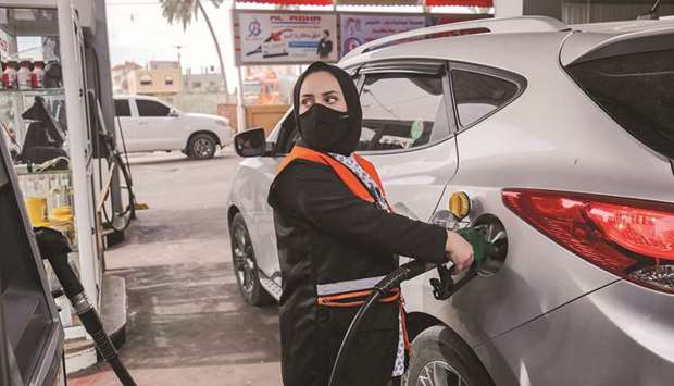 Salma al-Najjar, a 15-year-old Palestinian who works at a petrol station to help her family with income, refuels a car in Khan Yunis in southern Gaza Strip.