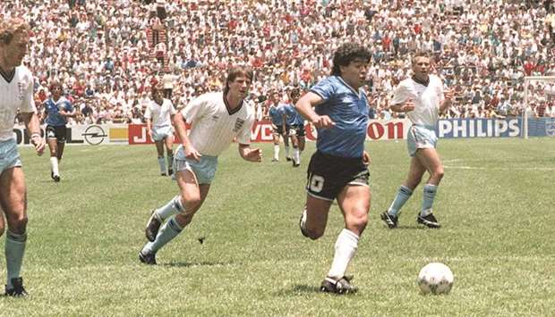 In this June 22, 1986, picture, Argentinian forward Diego Maradona runs past English defenders Terry Butcher (left) and Terry Fenwick (second from left) on his way to score his second goal during the World Cup quarter-final. (AFP)