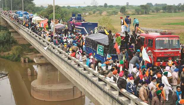 Farmers gather on a bridge as police block a road during a march to New Delhi to protest against the central governmentu2019s recent agricultural reforms, on the outskirts of Ambala yesterday.