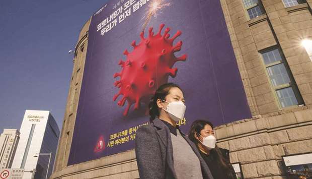 A poster warning against the Covid-19 coronavirus is displayed in Seoul yesterday. Bank of Korea governor Lee Ju-yeol has said the economy will likely shrink less than expected this year despite the worsening pandemic, though he issued a warning over rapid won gains that could undermine the pace of recovery.