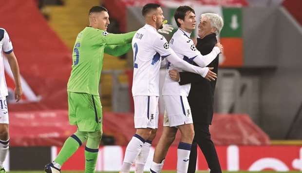 Atalantau2019s coach Gian Piero Gasperini (right) celebrates with his players after their win over Liverpool in the UEFA Champions League at Anfield in Liverpool, north west England on Wednesday night. (AFP)