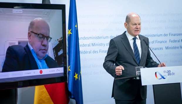 German Finance Minister and Vice-Chancellor Olaf Scholz (R) and German Economy Minister Peter Altmaier (on screen) attend a press conference on financial support amid the novel coronavirus pandemic in Berlin