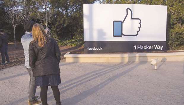 Pedestrians take photographs of signage displayed outside Facebook offices in Menlo Park, California. Facebooku2019s human moderators have focused on election and Covid-19 misinformation this year, so the company has leaned more on artificial intelligence algorithms to monitor other areas of the platform. Thatu2019s left many small businesses caught in Facebooku2019s automated filters, unable to advertise through the service.