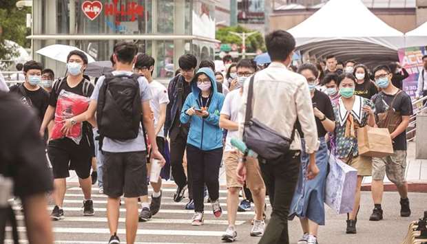 Pedestrians wearing protective masks cross a road in Taipei, Taiwan. An informal US-led alliance to provide an alternative to Chinau2019s Belt and Road Initiative will provide greater transparency to countries seeking funding to develop their infrastructure, Taiwanu2019s finance minister said.
