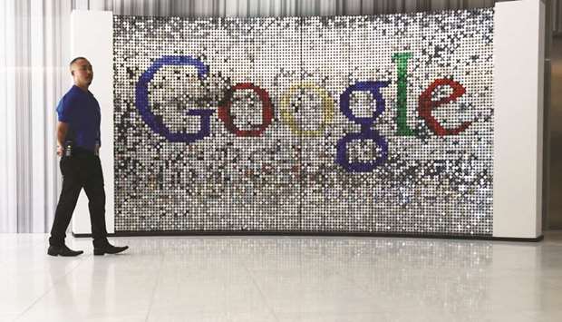 An employee stands next to a sign featuring Google logo inside their UK headquarters at Six St Pancras Square in London. Next month the EU is to present its own major legislation called the Digital Services Act, which will set out rules for strict oversight over big tech.
