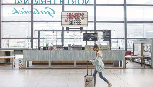 A traveller pushes a suitcase past a closed cafe near the check-in desks at London Gatwick Airport in Crawley. Gatwick, Britainu2019s second busiest airport, is opening a new Covid-19 testing facility on Monday, offering passengers discounted tests.