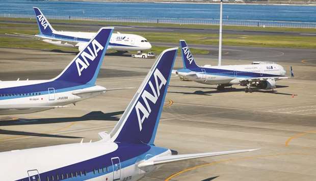 A tug pulls an All Nippon Airways Co aircraft past other planes operated by the airline at Haneda Airport in Tokyo. Japanu2019s largest carrier will raise as much as $3.2bn via an overseas and domestic share placement as airlines around the world rush to shore up their finances amid the coronavirus pandemic.