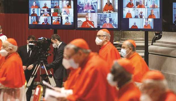 Absent cardinals appear on screens via video connection during a consistory ceremony at St Peteru2019s Basilica yesterday.