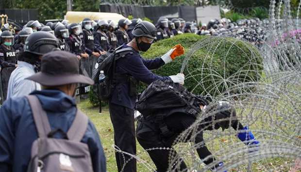 Protesters try to remove barb wires ahead of a pro-democracy rally demanding the prime minister to resign and reforms on the monarchy, in front of 11th Infantry Regiment, in Bangkok, Thailand