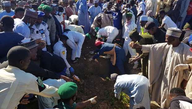 Men gather during the mass burial of people who were killed by militant attack, in Zabarmari, in the Jere local government area of Borno State, in northeast Nigeria