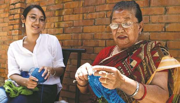 In this picture taken on August 6, 2020, business woman Lorina Sthapit (left) looks at her grandmother Champa Devi Tuladhar during an interview in Kathmandu.
