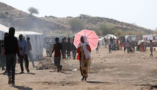 Ethiopian refugee walks with an umbrella at the Um Rakuba refugee camp which houses refugees fleeing the fighting in the Tigray region, on the Sudan-Ethiopia border in Sudan