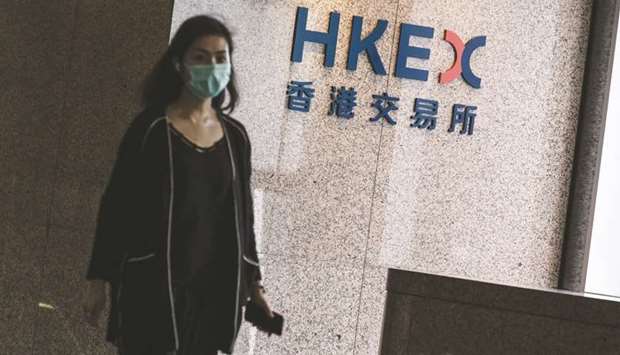 An employee walks past a signage for Hong Kong Exchanges & Clearing Ltd (HKEX) displayed at the Exchange Square complex in Hong Kong. HKEX led losses on Asia markets, shedding 1.8% to 26,417.42 points yesterday.