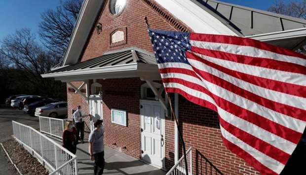 US flag flies as voters wait outside Hay Creek Town Hall on Election Day in Hay Creek, Minnesota