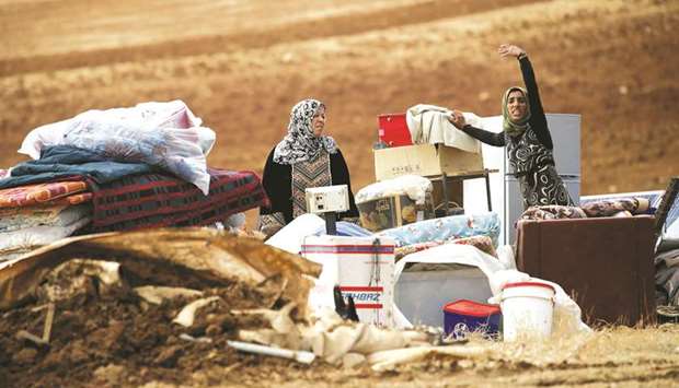 Palestinians stand next to their belongings after Israeli soldiers demolished their tents in an area east of the village of Tubas, in the occupied West Bank.