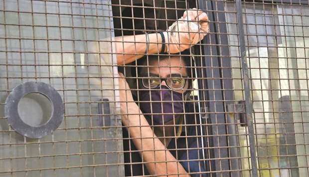 Goswami sits inside a police van outside a court after he was arrested, at Alibaug.