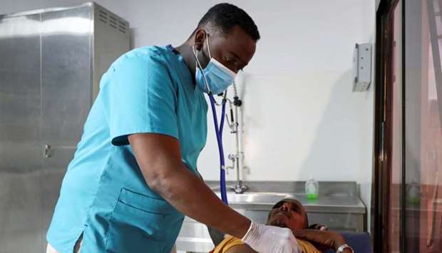 Somali doctor Abdullahi Shekhdoon, the managing director of Medipark Diagnostics lab that runs tests for the coronavirus disease (COVID-19), checks on a patient at the laboratory in Mogadishu