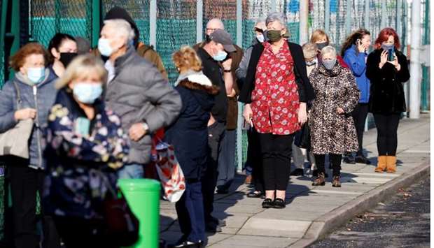 People queue at a coronavirus disease testing centre in Liverpool, Britain