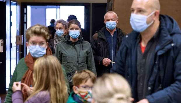 People wearing face masks cue to be tested for coronavirus Covid-19 during a mass testing in the Arena Nord in Frederikshavn, in Northern Jutland, Denmark